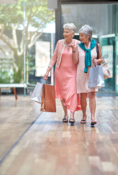 Theres a sale that caught my attention. Full length shot of a two senior women out on a shopping spree. - Фото, зображення