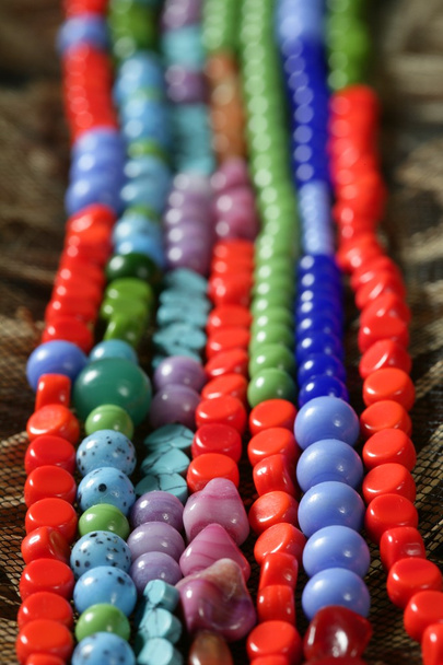 Color stones jewelry necklaces, straw background - Foto, Imagem