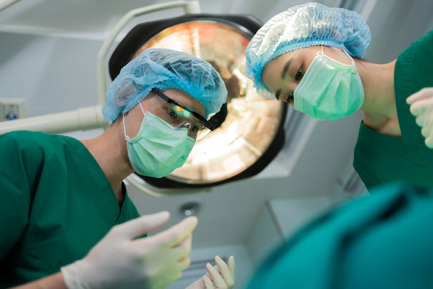 Low Angle Shot of Professional Chirurgové tým provádějící chirurgii na operačním sále, chirurg, Asistenti, a sestry provádějící chirurgii na pacienta, zdravotní péče rakoviny a léčba onemocnění koncepce - Fotografie, Obrázek