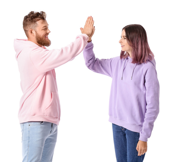 Cool jong paar in hoodies geven elkaar high-five op witte achtergrond - Foto, afbeelding