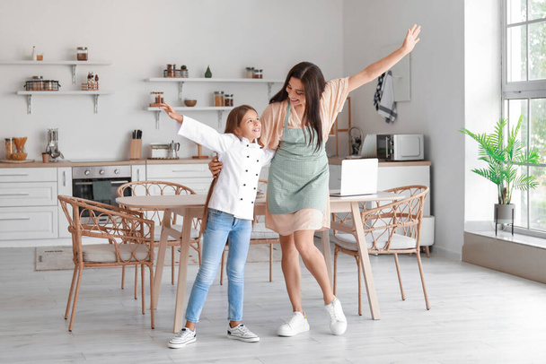 Glückliche Mutter und ihre kleine Tochter tanzen in der Küche - Foto, Bild