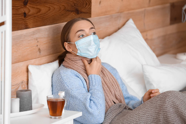 Плохая молодая женщина с больным горлом в постели - Фото, изображение