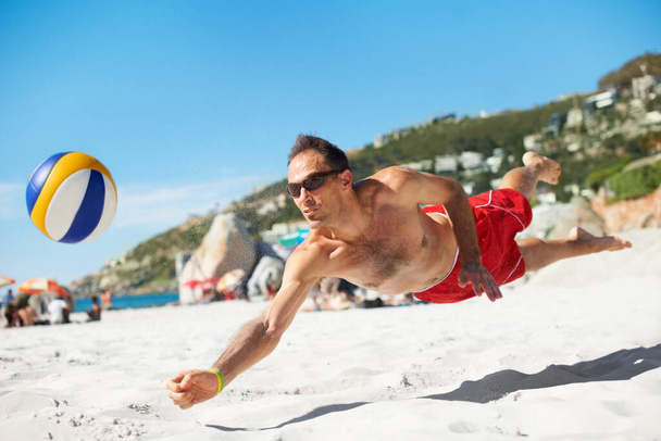 Прыжки в воду славы. Съемка игры в пляжный волейбол в солнечный день. - Фото, изображение