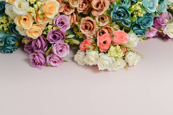  flores de primavera, rosas de diferentes colores sobre un fondo rosa pálido, espacio libre para el texto, elegante composición de primavera, marco de flores - Foto, imagen