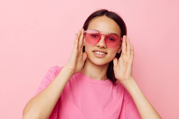 photo pretty woman in stylish glasses posing emotions pink background - Фото, зображення