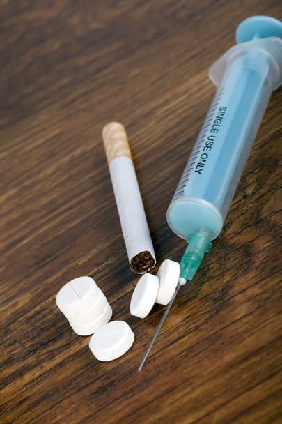 Conceito de dependência com seringa, cigarro e pílulas
 - Foto, Imagem