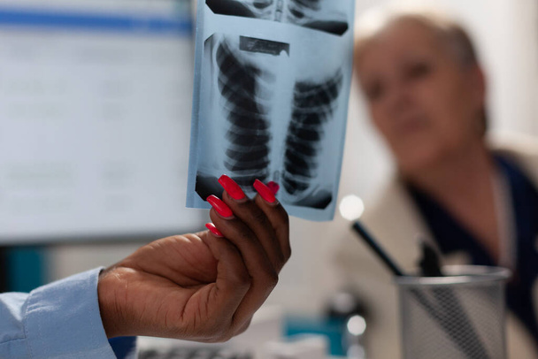 Κλείσιμο ιατρού με ακτινογραφία πνευμόνων που εξηγεί την εμπειρογνωμοσύνη σε ασθένειες - Φωτογραφία, εικόνα