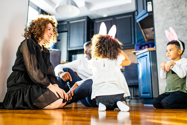 multicultural hispanic family wearing rabbit ears in living room soft sun day light - Photo, image