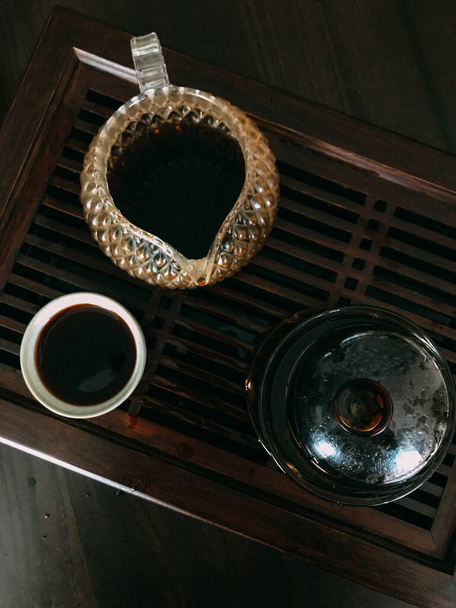 brewed tea, Chinese puer black tea, tea ceremony on a wooden board with beautiful dishes - Fotografie, Obrázek