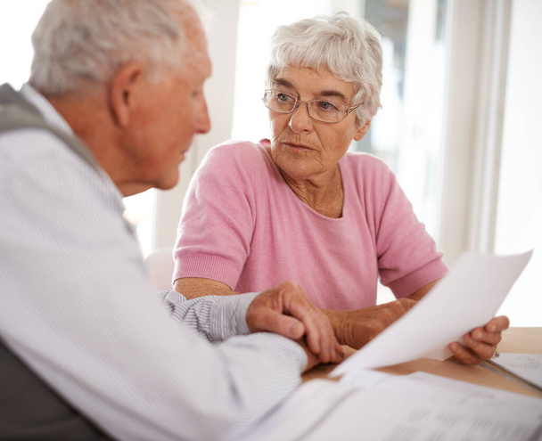 Taking time to discuss important matters. Shot of two elderly people discussing a document. - Foto, Imagem
