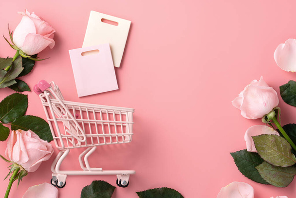Valentine's Day shopping design concept background with pink rose flower and cart on pink table background - Foto, Bild
