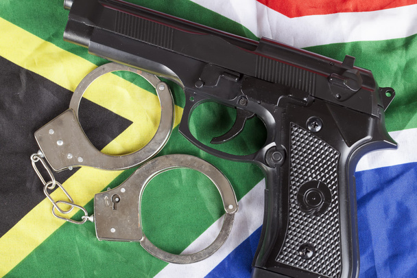 Έγκλημα και δικαιοσύνης έννοια με πιστόλι την Νοτιοαφρικανικά σημαία - Φωτογραφία, εικόνα