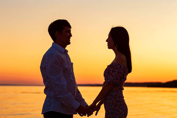 a guy with a girl on the background of the sunset sky - Fotografie, Obrázek
