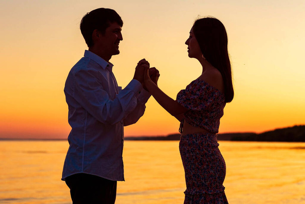 a guy with a girl on the background of the sunset sky - Fotoğraf, Görsel