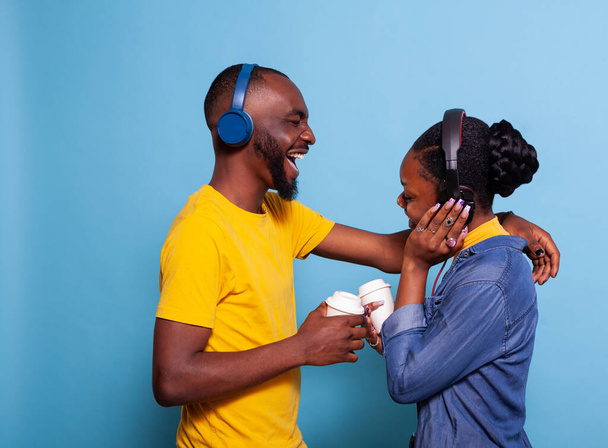 Girlfriend and boyfriend singing and having fun with song on headphones - Photo, Image