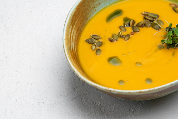 pumpkin soup garnished with pumpkin seeds on a white background - Photo, image