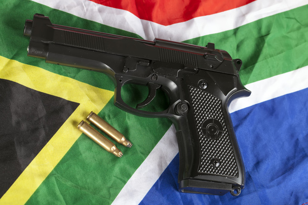 Handfeuerwaffe und Messingkugeln auf südafrikanischer Flagge - Foto, Bild