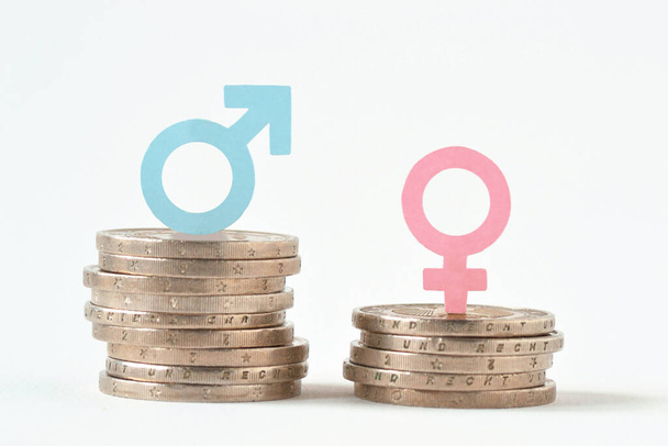 Symboles masculins et féminins sur piles de pièces - Concept d'égalité salariale entre les sexes - Photo, image