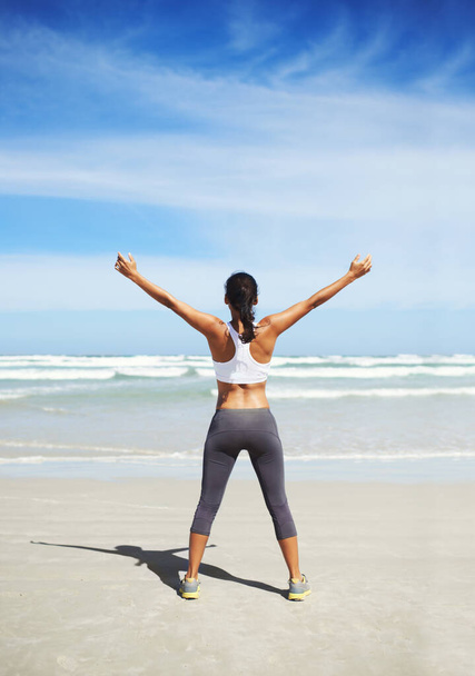 Fit and healthy. A young jogger standing on the beach. - Foto, Imagem