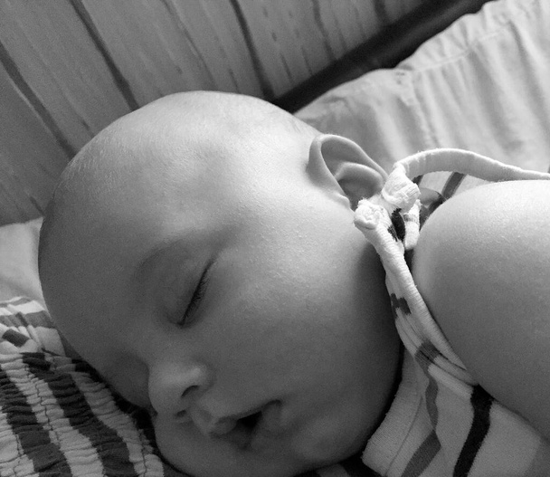 Menino adormecido com roupas infantis posando fotógrafo para foto colorida, quadro consistindo de bebê dormindo menino fora de roupas infantis, rosto expressão caucasiana, bebê dormindo saudável menino em roupas infantis - Foto, Imagem