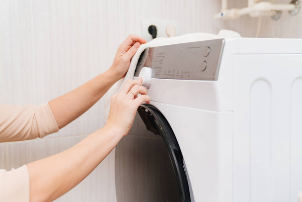 a woman turn the on the washing machine.  - Foto, Imagen