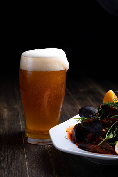 μπύρα με μύδια σε σάλτσα ντομάτας με μικροχόρτα και λεμόνι, σε ξύλινο φόντο - Φωτογραφία, εικόνα
