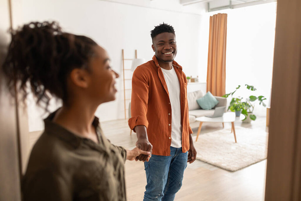 Sposi neri in piedi in porte che tengono le mani entrare in una nuova casa - Foto, immagini