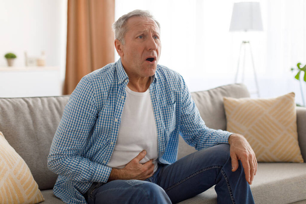 Ανώτερος άνθρωπος που πάσχουν από στομαχόπονο, αγγίζοντας κοιλιά - Φωτογραφία, εικόνα