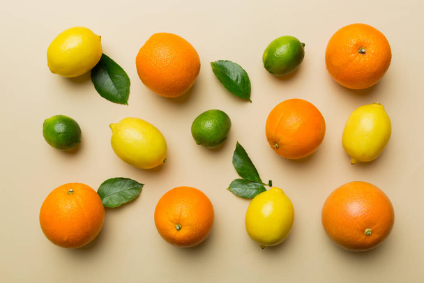 Flat lay of citrus fruits like lime, orange and lemon with lemon tree leaves on light colored background. Space for text healthy concept. Top view. - Foto, afbeelding