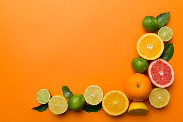 Fruit background. Colorful fresh fruits on colored table. Orange, lemon, grapefruit Space for text healthy concept. Flat lay, top view, copy space. - Fotó, kép