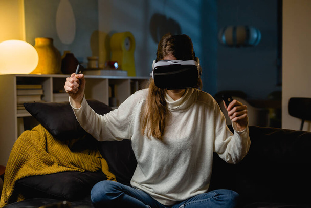 woman using virtual reality headset at home - Foto, afbeelding