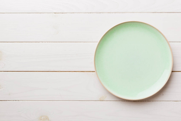 Κάτοψη του κενός πράσινου πιάτου σε ξύλινο φόντο. Κενό χώρο για το σχεδιασμό σας. - Φωτογραφία, εικόνα