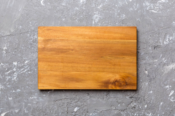 Top view of wooden cutting board on cement background. Empty space for your design. - Fotografie, Obrázek