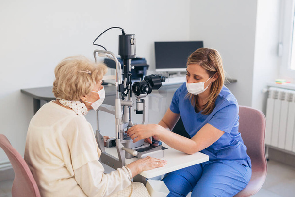 senior woman having eyesight examination. corona virus concept - Foto, Imagen