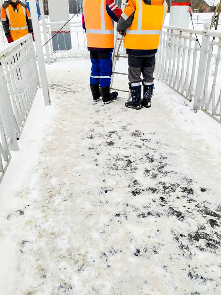 Pystysuora kuva 3 työntekijää oranssi liivit rautatiellä talvella - Valokuva, kuva