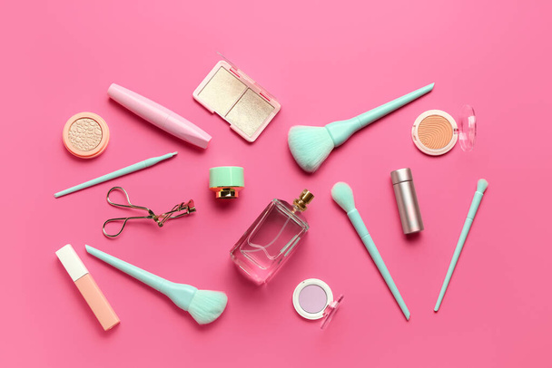 Composición con pinceles de maquillaje y productos cosméticos sobre fondo rosa - Foto, Imagen