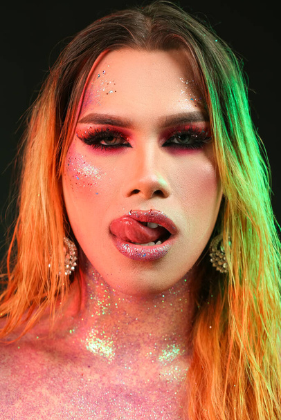 Модна молода транссексуальна жінка з блискітками на тілі на темному фоні
 - Фото, зображення