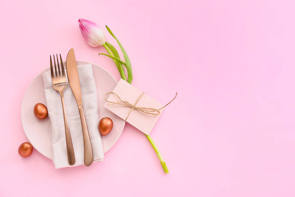 Beautiful table setting with Easter eggs and tulip on pink background - Photo, Image