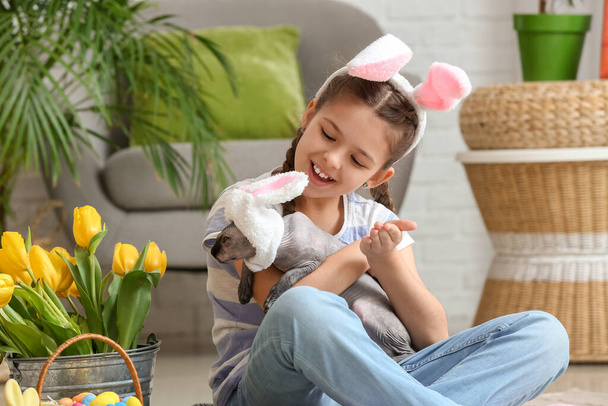 Little girl with Sphynx cat, Easter eggs and tulips at home - Foto, immagini
