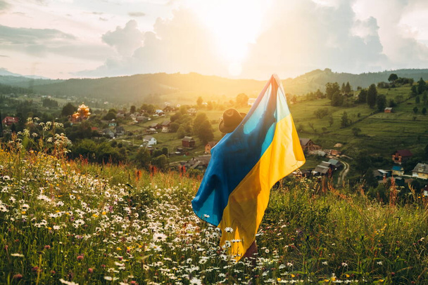 Людина з прапором України на тлі гір. Незалежна Україна. - Фото, зображення
