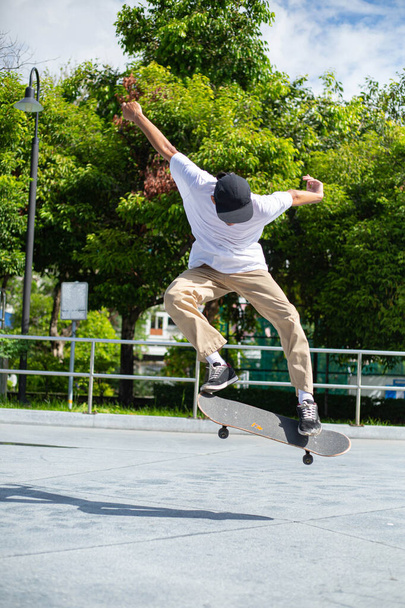 Skateboard man flip board in the sport area.Sport man funny with his hobby in the outside. - Fotografie, Obrázek