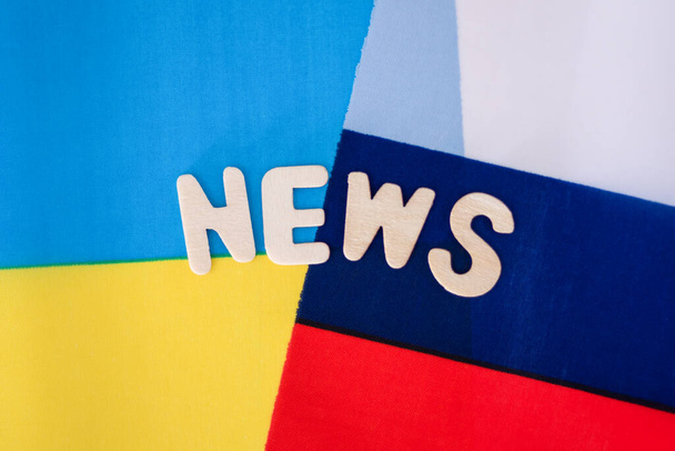 La bandera de Rusia y la bandera de Ucrania cruzaron entre sí, News Inscription. El concepto de noticias en Ucrania y Rusia. - Foto, imagen