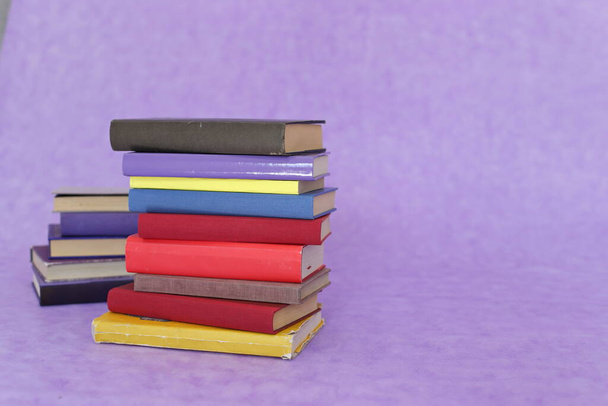 Stapel boeken over paarse achtergrond - Foto, afbeelding