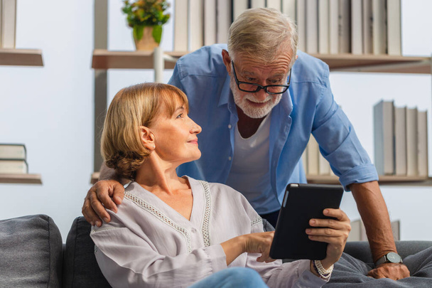 Dojrzałe kobieta i starszy mężczyzna za pomocą smartfona rozmowy na wideo rozmowy na przytulnej kanapie w domu, Portret wesołej pary seniorów w salonie, Happy koncepcji rodziny - Zdjęcie, obraz