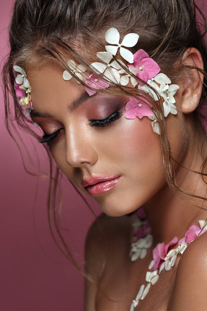 Beautiful caucasian woman with flowers on pink background. - Fotografie, Obrázek