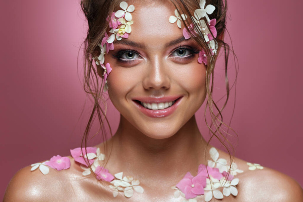 Beautiful caucasian woman with flowers on pink background. - Valokuva, kuva