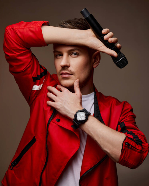 handsome male singer in red jacket with microphone - Фото, зображення