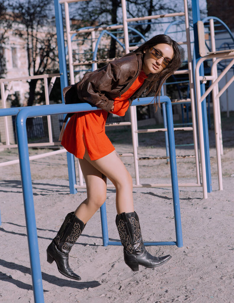 Stylish Girl in fashionable clothes walking on the playground - Fotó, kép
