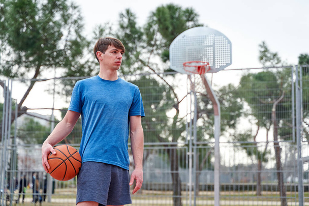 Retrato de un joven jugador de baloncesto en la cancha - Foto, imagen