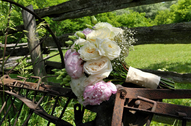 Primer plano de rosa blanca y rosa peonías ramo de bodas en Rusty Farm Equipment - Foto, Imagen